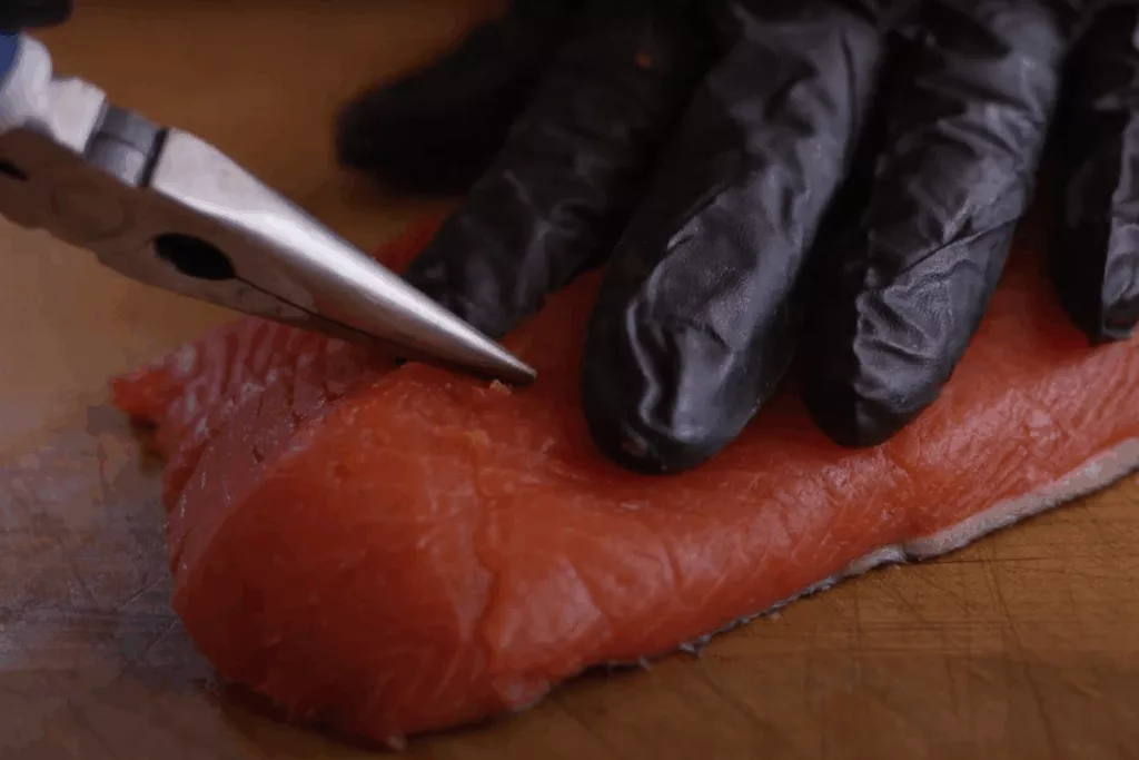 salmon with pliers with hand